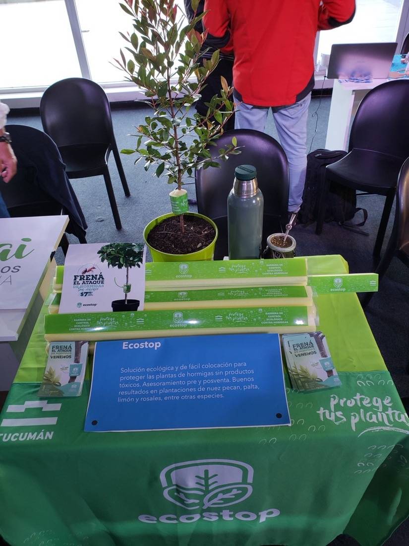 Stand de Ecostop en una exposición, con barreras, folletos y mantel de la marca