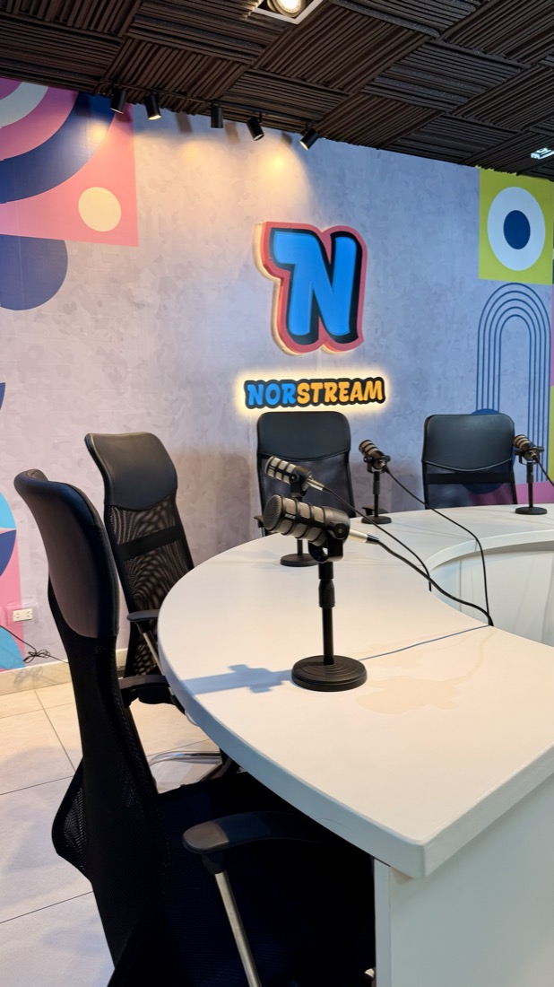 Cartel luminoso de Norstream junto a un micrófono de estudio
